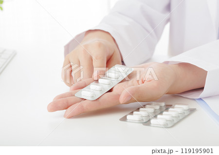 処方薬の説明をする白衣の女性(顔なし) 処方薬の説明をする白衣の女性(顔なし) 119195901