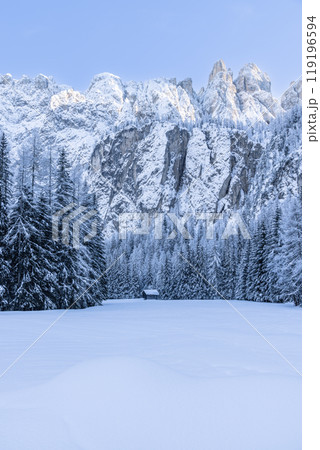 Snowy fields and cabin with Dolomite peaks in background 119196594