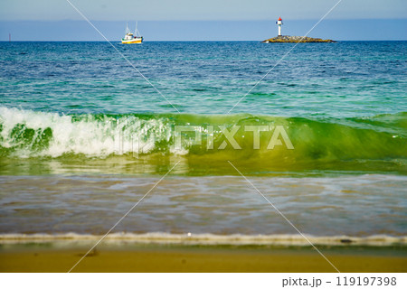 Seascape sandy beach with lighthouse on horizon Seascape sandy beach with lighthouse on horizon 119197398