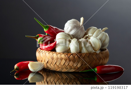 Garlic bulbs and red chili peppers on a black background. 119198317
