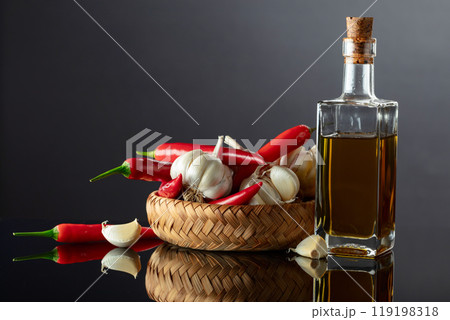 Garlic bulbs, red chili peppers, and bottle of olive oil. 119198318