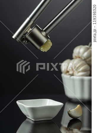 Garlic bulbs and garlic press. 119198320