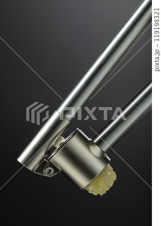 Garlic press on a black background. 119198321