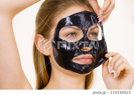 Girl removes black mask from face Girl removes black mask from face 119198923