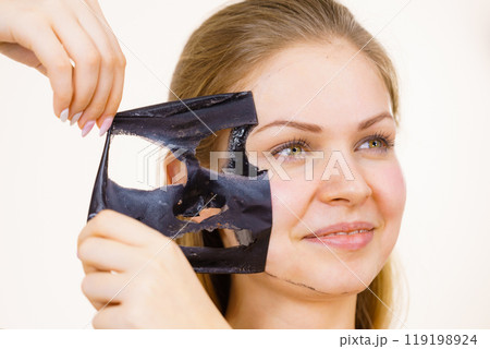 Girl removes black mask from face Girl removes black mask from face 119198924