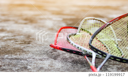 Broken badminton rackets lying on a dark surface, conveying the idea that sports and exercise are better alternatives to violence in society, promoting peace and healthy living. 119199917