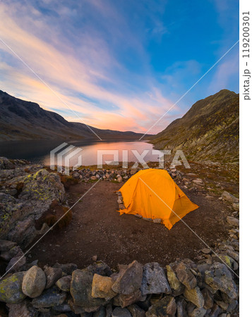 Orange Tent, Lake and Mountains at Sunset. Wild Camping in Jotunheimen National Park. Norway Orange Tent, Lake and Mountains at Sunset. Wild Camping in Jotunheimen National Park. Norway 119200301