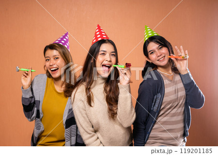 Friends joyfully celebrating in festive hats, showing cheerful expressions and energy 119201185