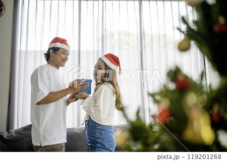 asian sweet couple exchanging christmas present 119201268