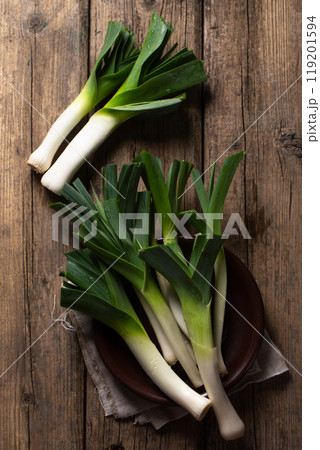 A green leeks in a brown bowl on a wooden table, top view A green leeks in a brown bowl on a wooden table, top view 119201594