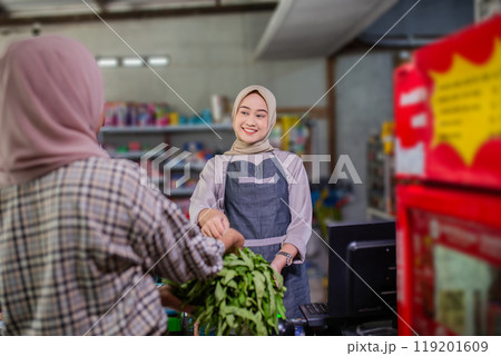 A Friendly Shopkeeper Happily Assisting a Customer with Fresh Vegetables in the Store A Friendly Shopkeeper Happily Assisting a Customer with Fresh Vegetables in the Store 119201609