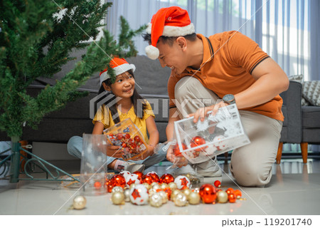 young father and daughter holding christmas ornament young father and daughter holding christmas ornament 119201740