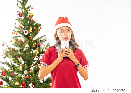 Holiday Cheer A Young Woman Joyfully Celebrating Christmas with a Smartphone in Hand Holiday Cheer A Young Woman Joyfully Celebrating Christmas with a Smartphone in Hand 119201764