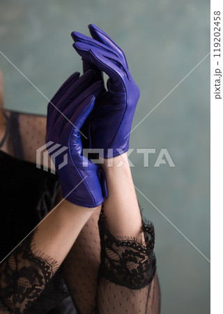 A woman in a black dress and blue leather gloves 119202458