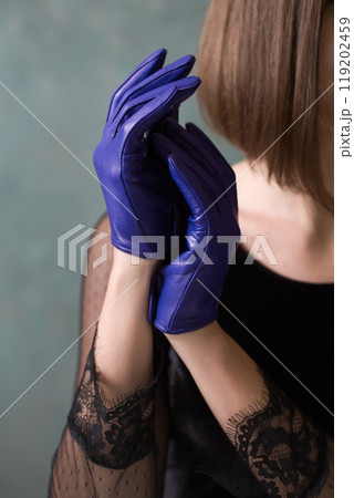 A woman in a black dress and blue gloves 119202459