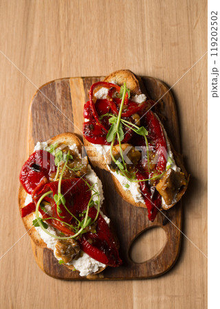 Sandwiches with mushrooms, grilled pepper and microgreen pea pods on a wooden board 119202502