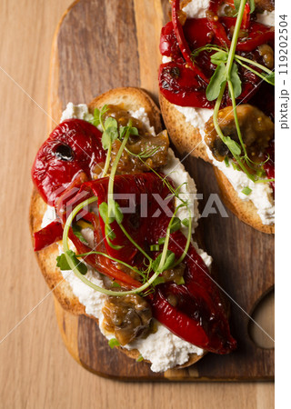 Sandwiches with cheese spread, mushrooms, grilled pepper and microgreen pea pods on a wooden board Sandwiches with cheese spread, mushrooms, grilled pepper and microgreen pea pods on a wooden board 119202504