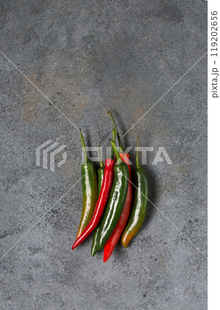 Several hot chili pepper pods on gray background, minimalism 119202656