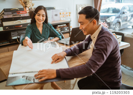 male customer pointing on the catalogue book while choosing the variety of window treatments 119203303