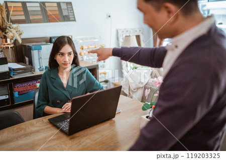 frustrated female shopkeeper glared to the male shop owner that scolding her frustrated female shopkeeper glared to the male shop owner that scolding her 119203325