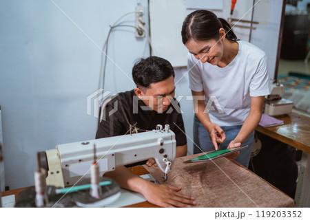 tailor paying attention to the tablet that showed by the production crew tailor paying attention to the tablet that showed by the production crew 119203352