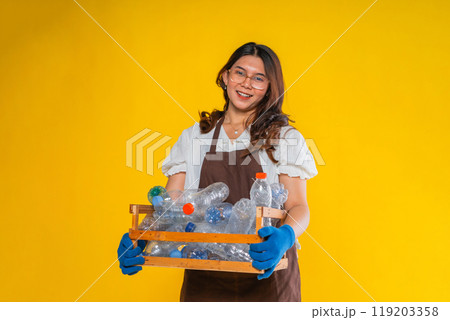 woman in apron holding plastic bottle in wooden storage woman in apron holding plastic bottle in wooden storage 119203358