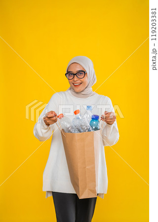 asian hijab woman sorting plastic bottle isolated plain yellow background asian hijab woman sorting plastic bottle isolated plain yellow background 119203381