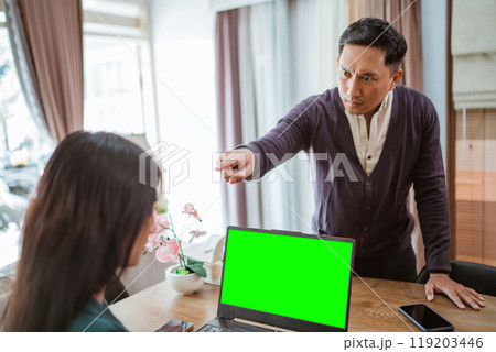 grumpy asian shop owner pointing on his employee while scolding at her 119203446
