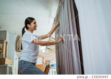asian production crew putting he curtain on hanger to setting the wave 119203447