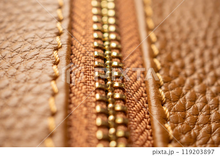 close up of zipper on brown leather bag 119203897
