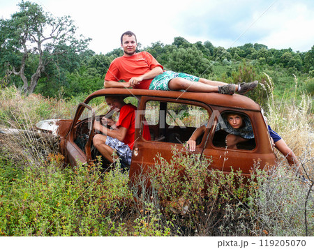 Friends Exploring an Abandoned Rusty Car in Nature Friends Exploring an Abandoned Rusty Car in Nature 119205070