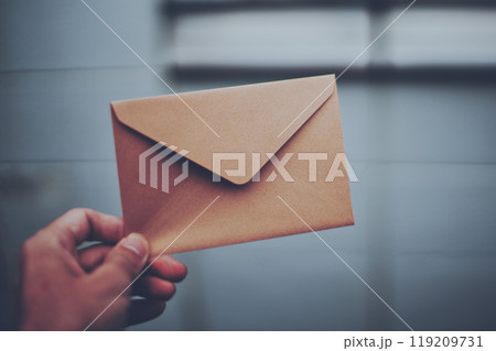 茶色の封筒を持つ人の手元 茶色の封筒を持つ人の手元 119209731