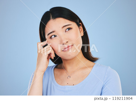 Decision, thinking and Asian woman with ideas, choice and problem solving on a blue studio background. Solution, Japanese person or model brainstorming, doubt and mockup space with questions or emoji 119211904