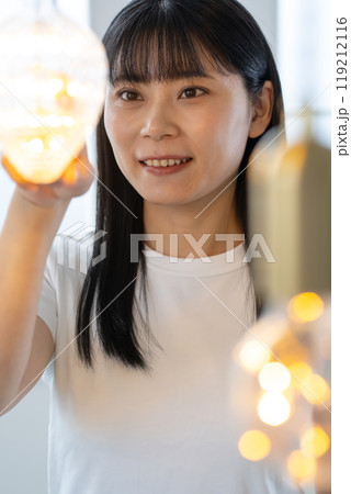 屋内のシャンデリアの中に立つ女性 119212116