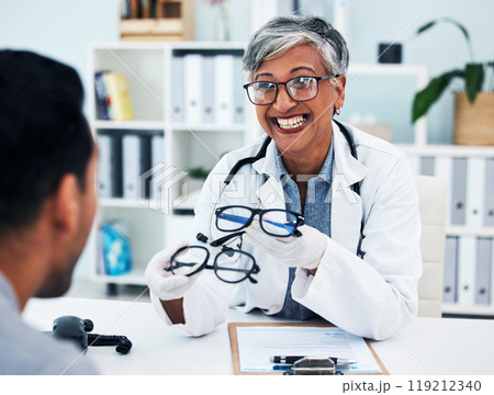 Optometrist, woman and customer with glasses for man or assessment for service at clinic. Eye doctor, professional and advice with frame or consultation with expert for client or helping with smile. 119212340