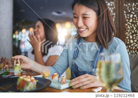 Japanese woman, restaurant and eating sushi with smile, chopsticks and excited for fine dining at party. Asian friends, fish and healthy with culture, traditional or fast food in diner, bar or shop Japanese woman, restaurant and eating sushi with smile, chopsticks and excited for fine dining at party. Asian friends, fish and healthy with culture, traditional or fast food in diner, bar or shop 119212468