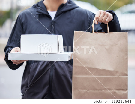 Courier man, paper bag and hands for pizza, service and delivery in urban city for supply chain job. Logistics worker, package and street for customer satisfaction, product or e commerce in metro cbd 119212641