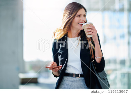 Start your morning with good ol caffeine. Cropped shot of an attractive young businesswoman drinking coffee while walking through a modern office. 119213967