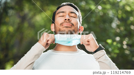 Covid, Asian man and take off mask for end of pandemic, breathing and outdoor protected. Corona, healthy guy and Japanese person remove face cover for fresh air, freedom and decrease infection rates 119214769