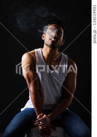 Smoking, sexy man and chair on black background in fitness inspiration, beauty aesthetic and sensual fashion. Erotic art, sexual body and male model with muscle, cigarette and studio in dark lighting 119214991