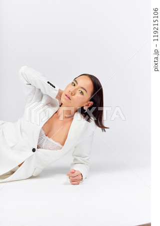 Fashion, beauty and portrait of a woman in a studio with a formal, classy and fancy outfit. Cosmetic, makeup and young Asian female model with elegant style posing while isolated by white background. 119215106