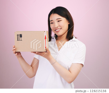 Happy asian woman, box and delivery in online shopping, supply chain or logistics against a pink studio background. Excited female person or shopper with package, parcel or cargo in ecommerce Happy asian woman, box and delivery in online shopping, supply chain or logistics against a pink studio background. Excited female person or shopper with package, parcel or cargo in ecommerce 119215138