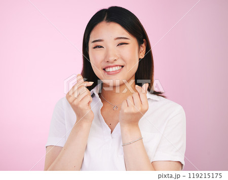 Happy asian woman, portrait and love hands, sign or gesture in romance against a pink studio background. Face of female person smile in happiness with loving emoji or symbol for valentines day 119215175
