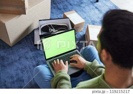 Ecommerce, man with computer, green screen and box on carpet, shoes and delivery service on digital app. Sale, discount and online shopping on fashion retail brand website, internet search on laptop. Ecommerce, man with computer, green screen and box on carpet, shoes and delivery service on digital app. Sale, discount and online shopping on fashion retail brand website, internet search on laptop. 119215217