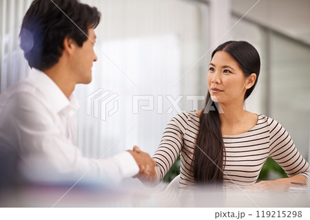Business people, handshake and agreement with colleague for meeting or deal together at the office. Young asian man and woman holding or shaking hands in b2b, greeting or partnership at the workplace 119215298