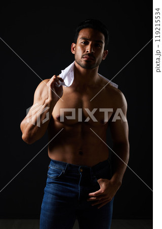 Sexy, muscle and portrait of man in studio with fitness inspiration, beauty aesthetic and sensual fashion. Erotic art, sexual body and male model sitting on black background, topless in dark lighting 119215534