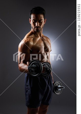 Muscle, strong and studio man with dumbbell challenge results, arm workout development and body fitness progress. Dark shadow, gym equipment and sports athlete with training focus on grey background 119215551