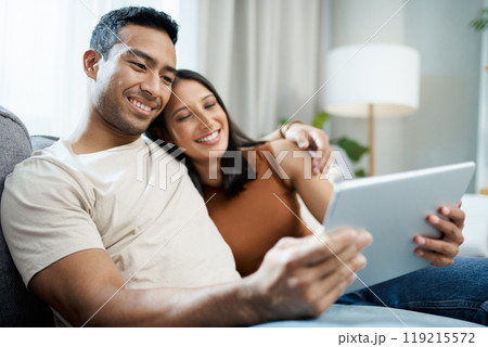 Happy couple, tablet and relax on sofa for online streaming, entertainment or social media at home. Man and woman sitting in living room with smile for technology, connection or networking at house Happy couple, tablet and relax on sofa for online streaming, entertainment or social media at home. Man and woman sitting in living room with smile for technology, connection or networking at house 119215572