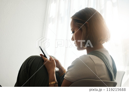 Phone, relax and young Asian woman in the living room sitting on a comfortable chair on a weekend. Calm, peaceful and female person networking on social media, mobile app or internet at apartment. Phone, relax and young Asian woman in the living room sitting on a comfortable chair on a weekend. Calm, peaceful and female person networking on social media, mobile app or internet at apartment. 119215688