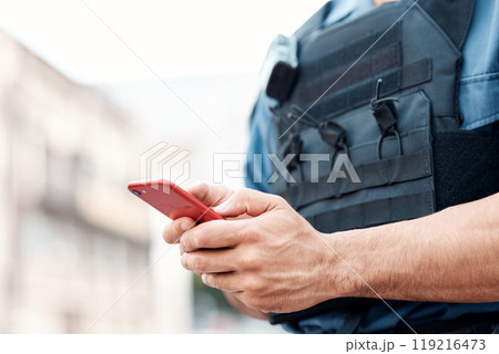 Man, police and hands with phone for communication, networking or social media in the city. Closeup of male person or officer typing, texting or chatting on mobile smartphone app in an urban town Man, police and hands with phone for communication, networking or social media in the city. Closeup of male person or officer typing, texting or chatting on mobile smartphone app in an urban town 119216473